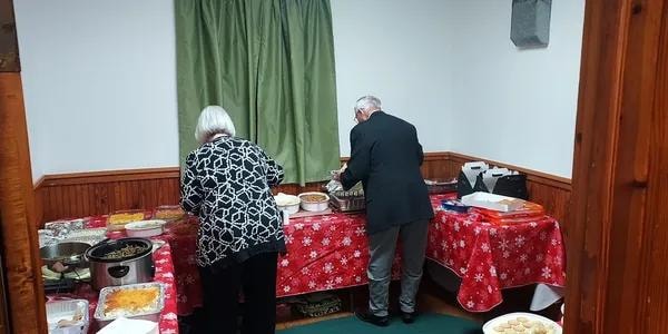 Members serving food at the buffet table
